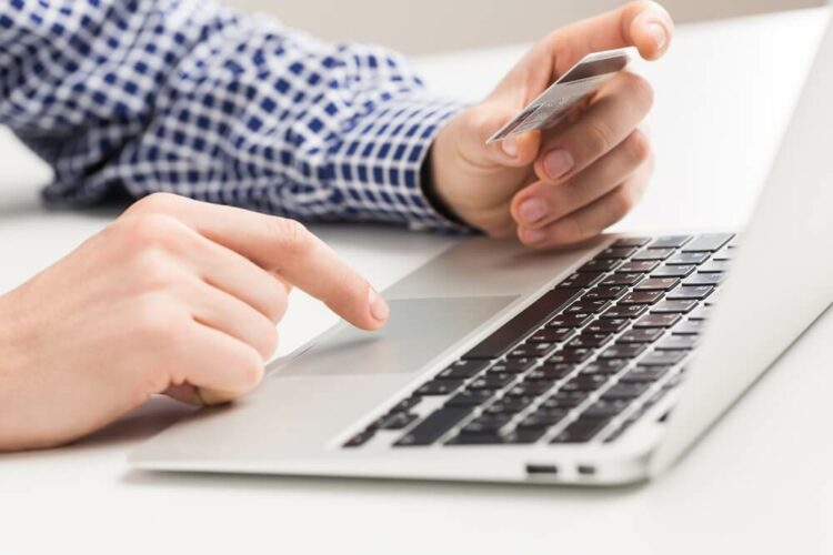 Man holding a credit card paying bill online