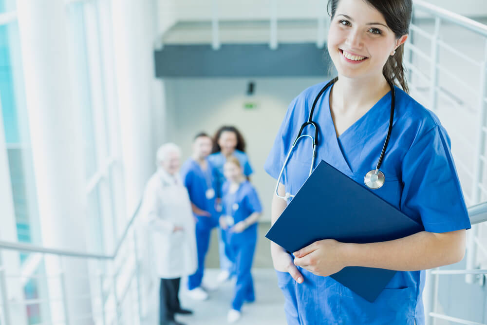 Happy, young woman in blue uniform during medical internship at a hospital