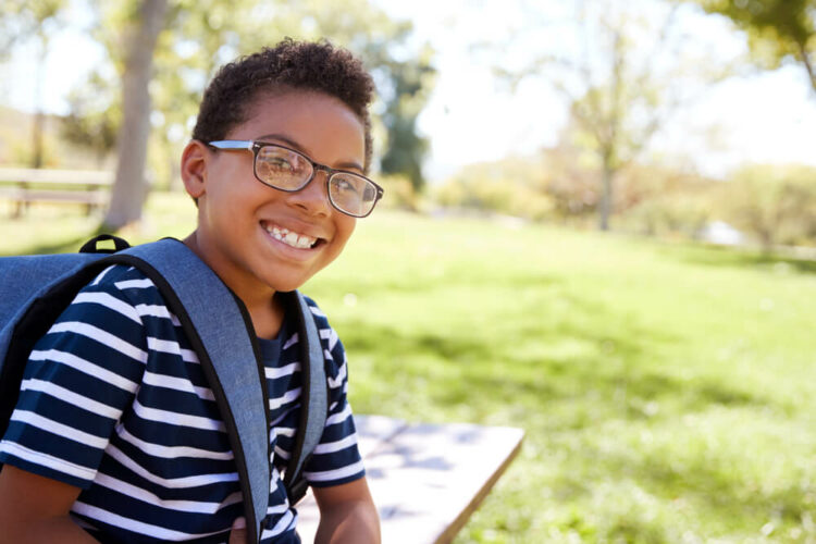 Young schoolboy in glasses smiling to camera